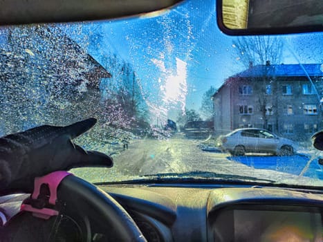 A vehicles windshield is covered with frost, reducing visibility and highlighting the challenges of winter driving
