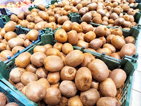 Fresh Kiwi Fruit Displayed for Sale at Market Stand. A selection of ripe kiwis in crates at a local market