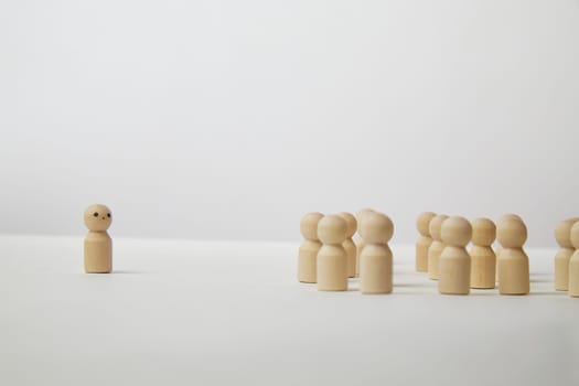 Wooden figurines with a leader and group with partial focus. The confrontation between the head and the employees. Outcast, different, different. Bullying at school, at work