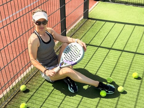 Happy female paddle tennis player during practice on outdoor court. Copy space. High quality photo