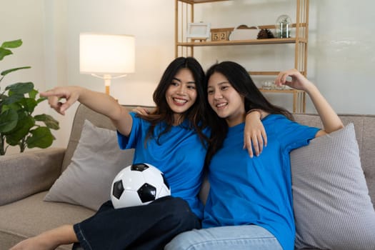 LGBT Soccer fans emotionally watching game in the living room.