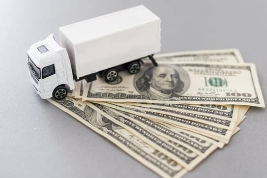 White toy truck lie on dollars, space for text. High quality photo