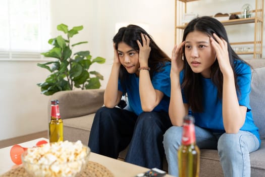 LGBT Soccer fans emotionally watching game in the living room.