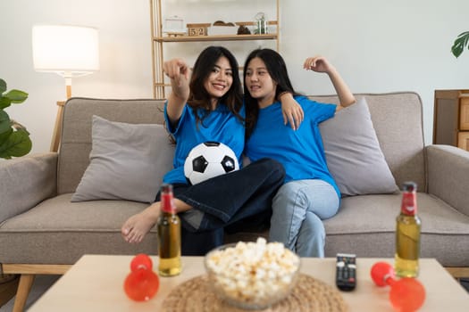 LGBT Soccer fans emotionally watching game in the living room.