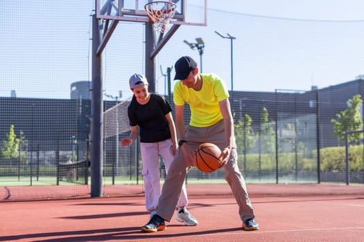 A father and daughter playing basketball in the park. High quality photo