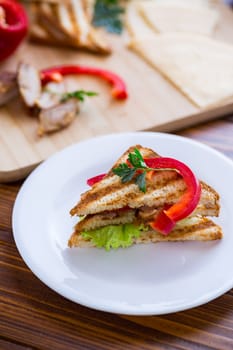 fried toast with chicken, salad, greens on a wooden table .