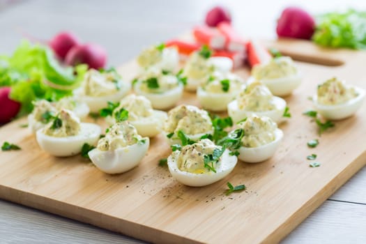 stuffed eggs, deviled eggs on a wooden table .