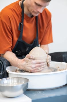 A potter working on a potter's wheel. Vertical photo