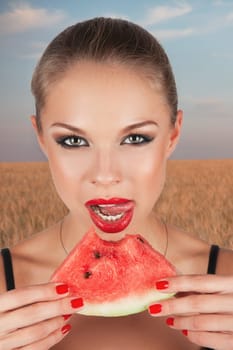 Girl holding slice of watermelon on the green and yellow summer background.