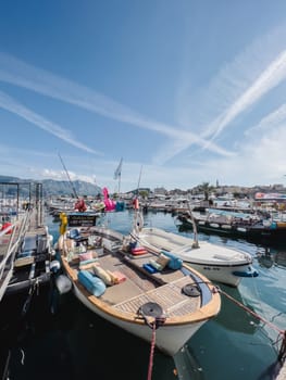 Small boats are moored on the pier against the backdrop of the mountains. High quality photo