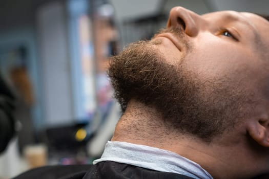 A man is waiting to cut a beard in the barbershop.