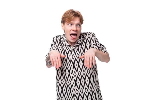 young red-haired caucasian man in a short-sleeved summer shirt makes a grimace.