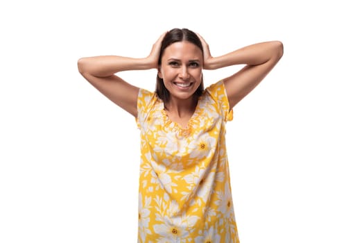 young brunette woman with straight hair dressed in a casual yellow T-shirt smiling friendly.