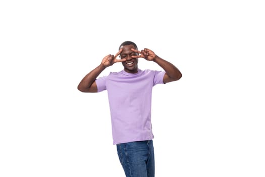 young authentic slender american guy dressed in light lilac t-shirt and jeans.