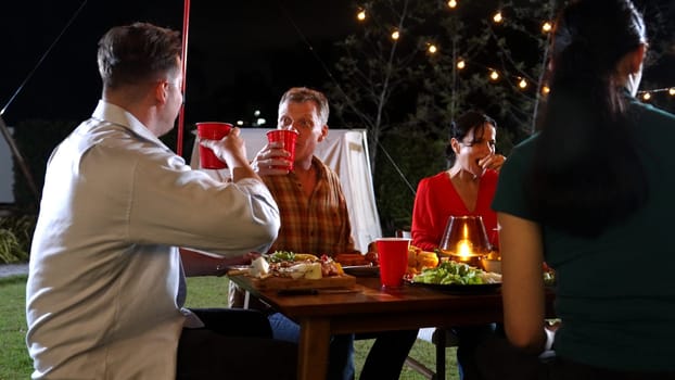 Family gather celebrate holiday. Focus father, grandmother and grandfather talk and have dinner party food. Outdoor activity for spending time with polite relatives strengthen family bond. Divergence.