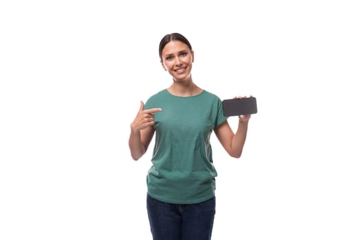 well-groomed slim young brunette woman dressed in a green t-shirt with surprise holding a smartphone.