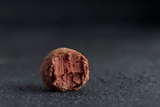 Premium gourmet chocolate handmade truffle from confectionery, homemade dark chocolate candy on black background