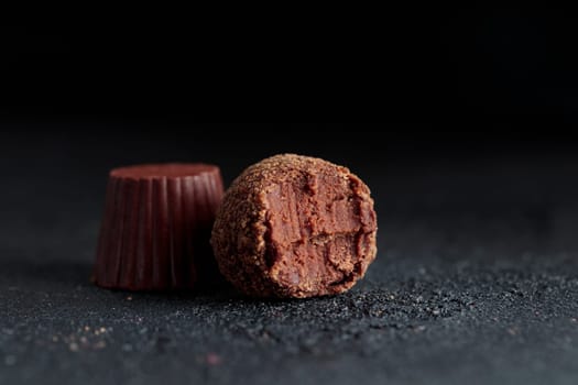 Premium gourmet chocolate handmade truffles from confectionery, homemade dark chocolate candies on black background