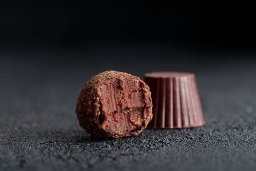 Premium gourmet chocolate handmade truffles from confectionery, homemade dark chocolate candies on black background