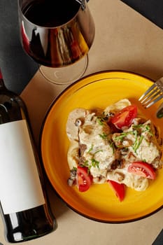 Culinary delight of spicy veal ribs with peanut puree, mushroom cream sauce and fresh cherry tomatoes, paired with bottle of red wine, served on sunny yellow plate