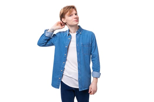 young european man with red hair wears a blue denim shirt thinks about an idea.