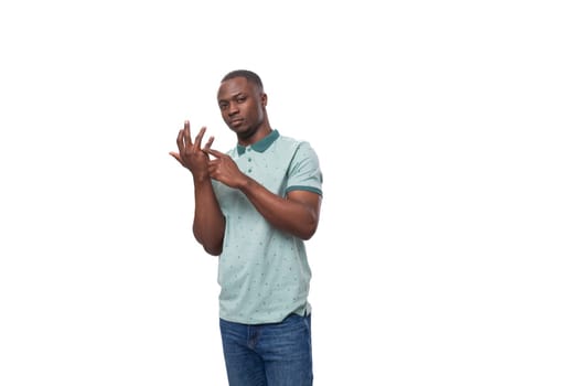 a young smart American guy dressed in a mint T-shirt counts on his fingers.