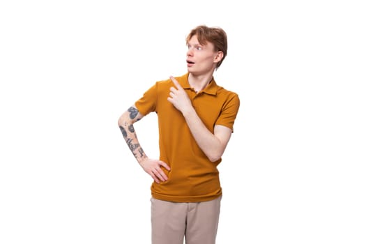 surprised red-haired guy dressed in an orange t-shirt on a white background.