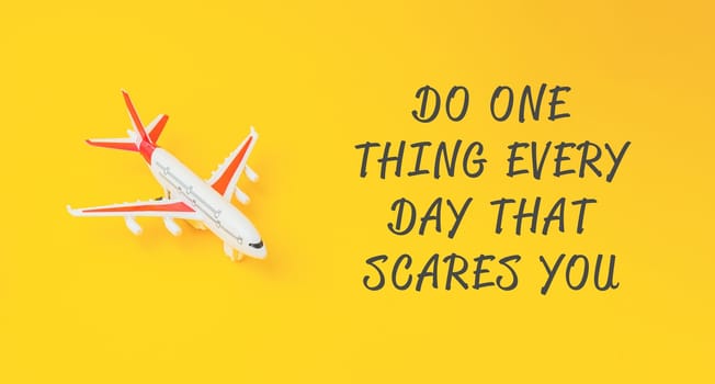 A small airplane is on a yellow background with the words Do one thing every day that scares you. written below it
