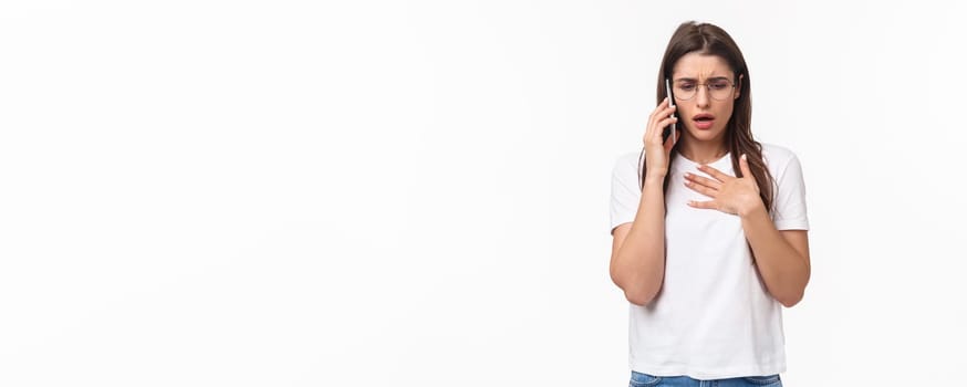 Communication, technology and lifestyle concept. Portrait of concerned and worried young woman express compassion and worry, calling sick friend asking if she okay, hold mobile near ear, touch heart.