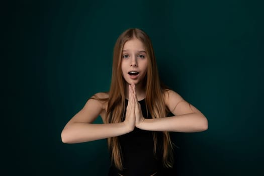 A young girl with a surprised expression on her face, her hands are raised in front of her. She appears startled or shocked by something in her environment. The girls eyes are wide open, and her mouth is slightly agape.