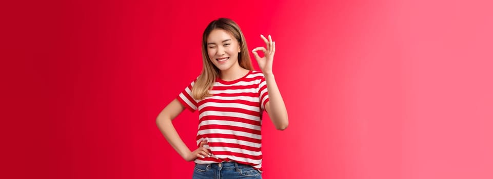 Good job mate. Proud happy female coworker approve your effort show okay gesture winking joyfully congratulate friend excellent plan, say well done make ok good approval gesture, red background.