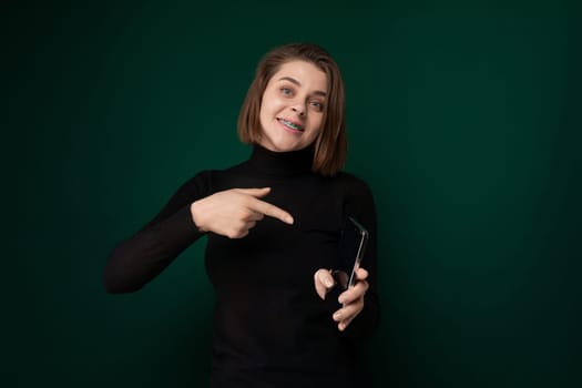 A woman is pointing with her finger towards an unspecified object or direction. She appears engaged and focused, gesturing with intent.