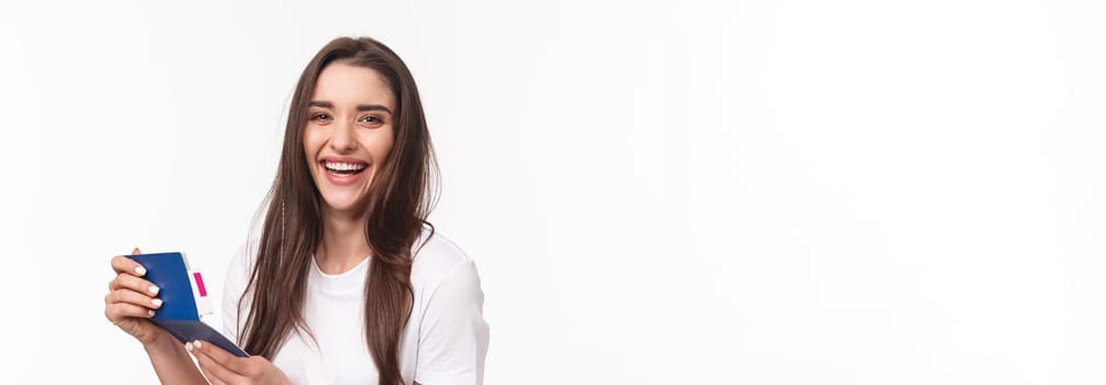 Travelling, holidays, summer concept. Close-up portrait of happy, charismatic pretty woman laughing, looking at her visa in passport with plane ticket, smiling joyful camera, ready for journey.