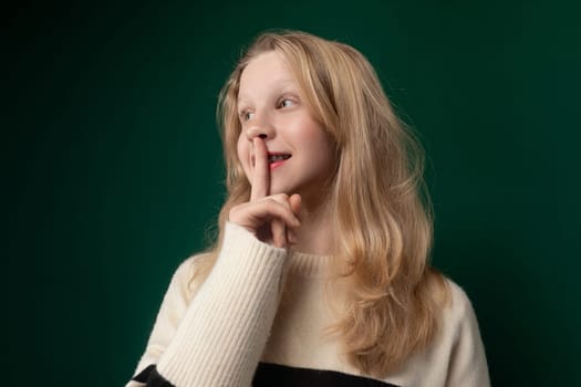 A woman standing and posing for a picture with her finger in her mouth, looking directly at the camera.