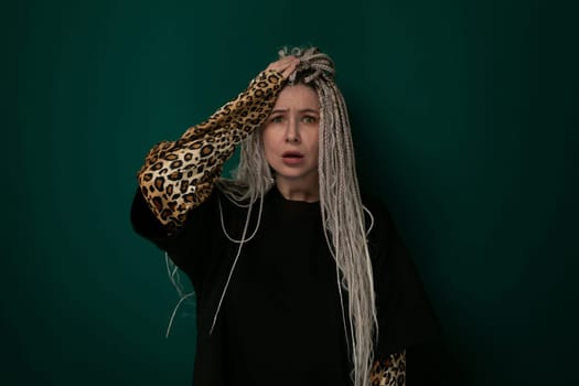 A woman with long hair is wearing a leopard print scarf. She is standing against a neutral background, looking directly at the camera.