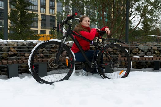 Lifestyle concept, young woman riding a bike in winter weather around the city.