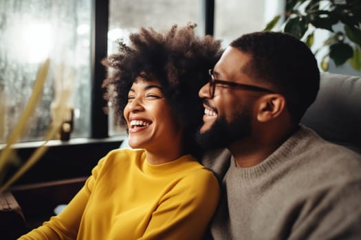 Portrait of happy smiling young couple hugging, cheerful woman and man sitting on sofa at home together