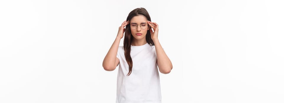 Waist-up portrait of attractive young woman trying get ready, massaging temples with closed eyes as relaxing, ease the pain, thinking rational, put effort into making up plan, white background.