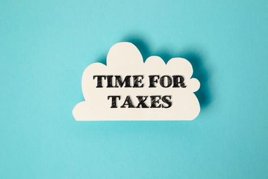 A white cloud with the word time for taxes written in black. The image has a somewhat serious and somber mood