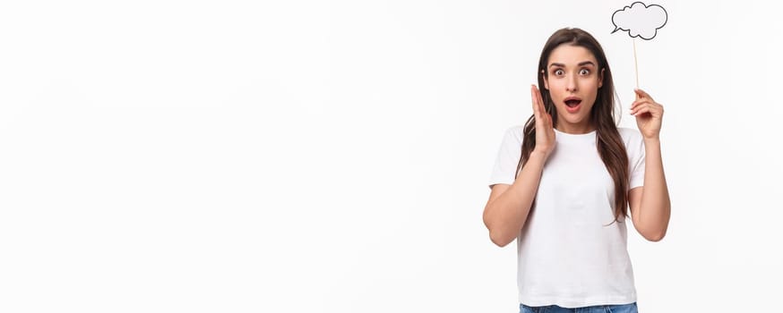 Entertainment, fun and holidays concept. Portrait of excited and happy, surprised young girl have awesome idea, holding comment cloud near head as if have plan, thinking, gasping in awe.