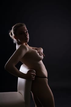 Photo of a gentle seductive topless plump lady isolated on black background