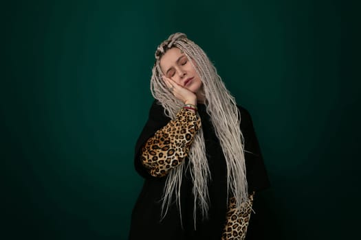 A woman with long white hair wearing a leopard print shirt is standing confidently in a room. She exudes a strong and stylish presence with her striking appearance.