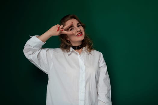 A woman wearing a white shirt is striking a pose for a photograph. She appears confident and relaxed as she looks directly at the camera. Her posture is elegant and poised, creating a visually appealing image.