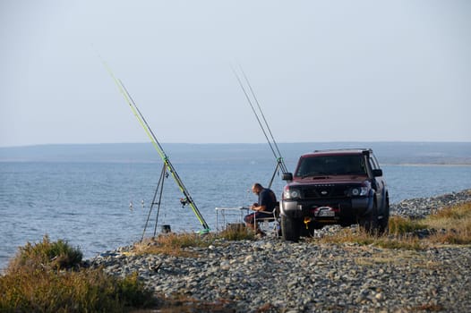 fisherman catches fish on the seashore