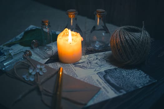 Mystical still life in vintage style with empty flasks, burning candles, letters and newspaper clippings. High quality photo