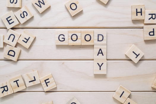 A jumble of wooden letters spell out the word good day. Concept of playfulness and creativity, as the letters are arranged in a fun and unconventional way