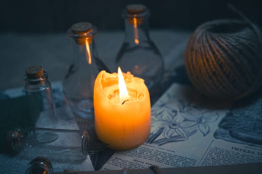 Mystical still life in vintage style with empty flasks, burning candles, letters and newspaper clippings. High quality photo