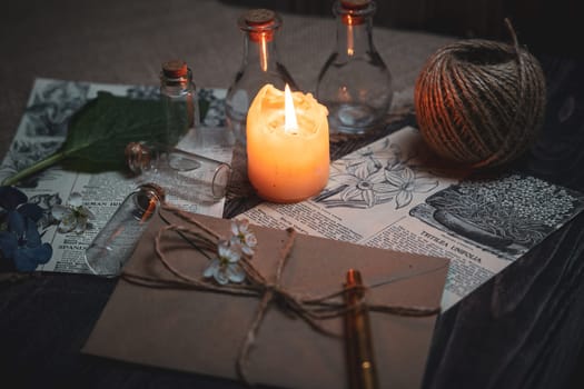 Mystical still life in vintage style with empty flasks, burning candles, letters and newspaper clippings. High quality photo