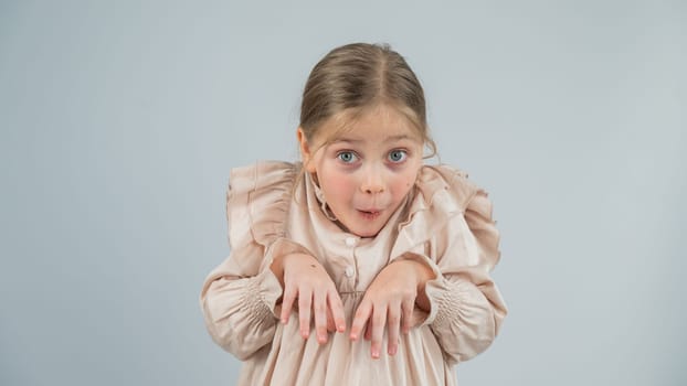 Little Caucasian girl having fun and making faces on a white background