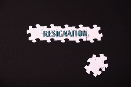 A puzzle piece labeled resignation, symbolizing the acceptance and acknowledgment of change or departure in various contexts.